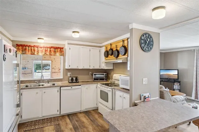 a kitchen with a sink cabinets and wooden floor