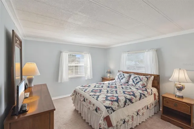 a bedroom with a bed and a lamp on dresser