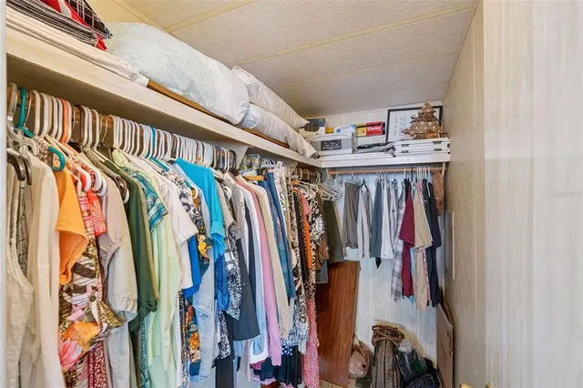 a view of walk in closet with clothes