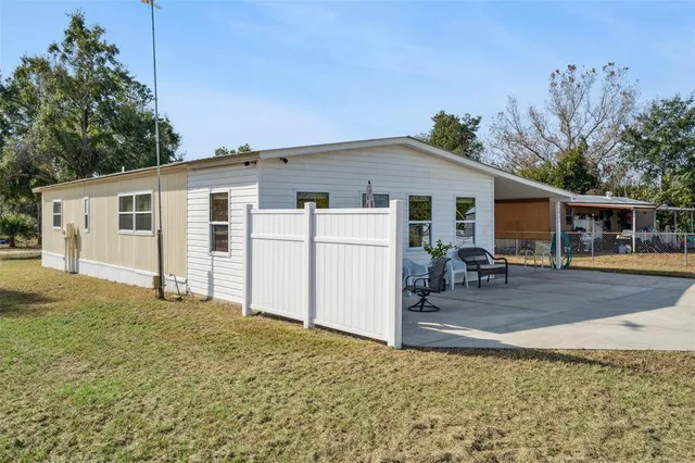 a view of a house with backyard and sitting area