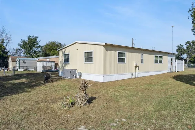 a view of a house with backyard and a tree