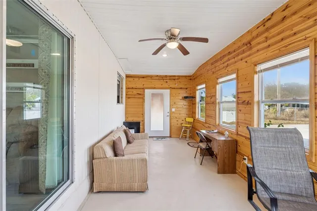 a living room with furniture and floor to ceiling windows