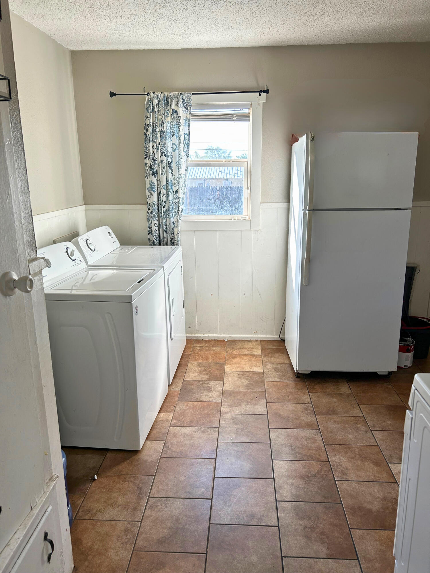 2205 39th Street Lubbock, TX 79412 - Photo 3 of 7 a utility room with a refrigerator washer and dryer