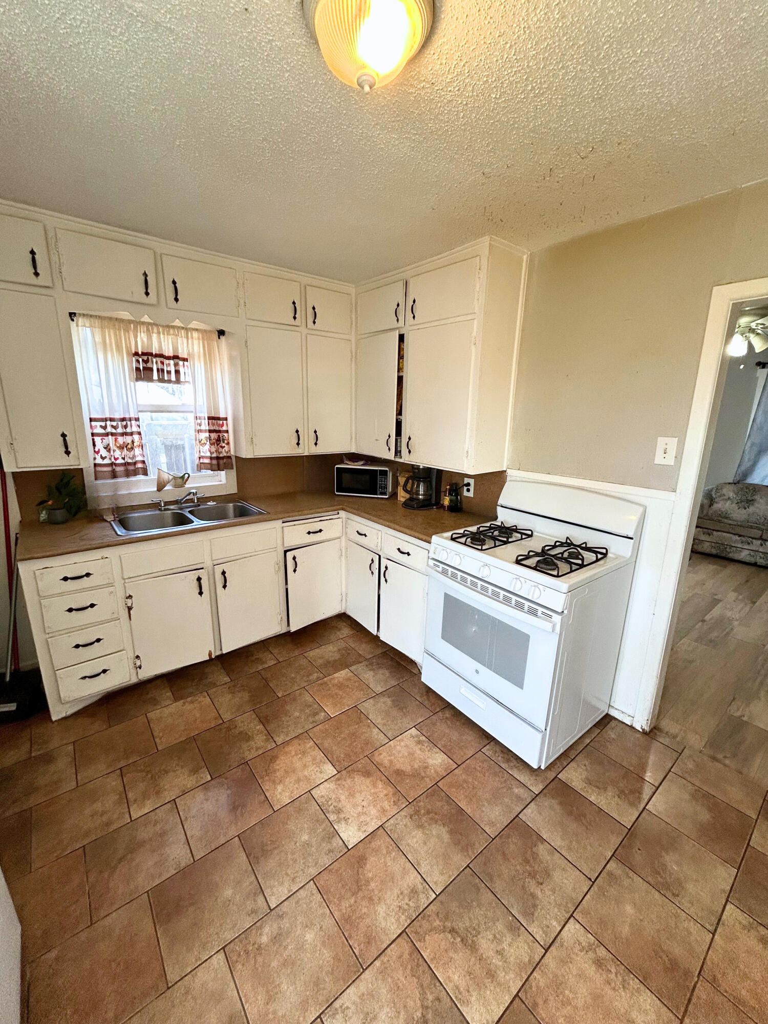 2205 39th Street Lubbock, TX 79412 - Photo 4 of 7 a kitchen with stainless steel appliances granite countertop a stove a sink and a refrigerator