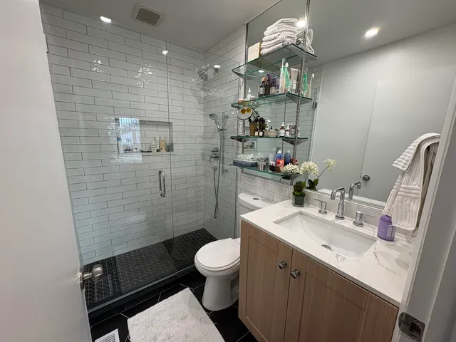 a bathroom with a sink a toilet and shower