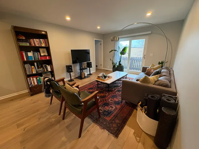 a living room with furniture a flat screen tv and a book shelf