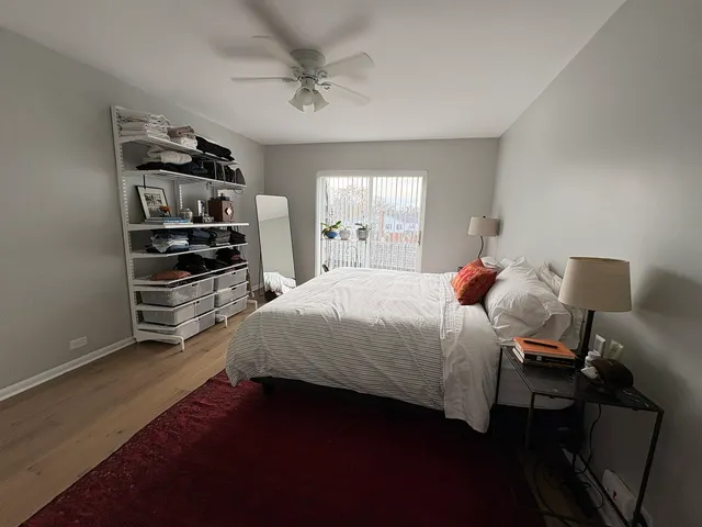 a bedroom with a bed wooden floor and window