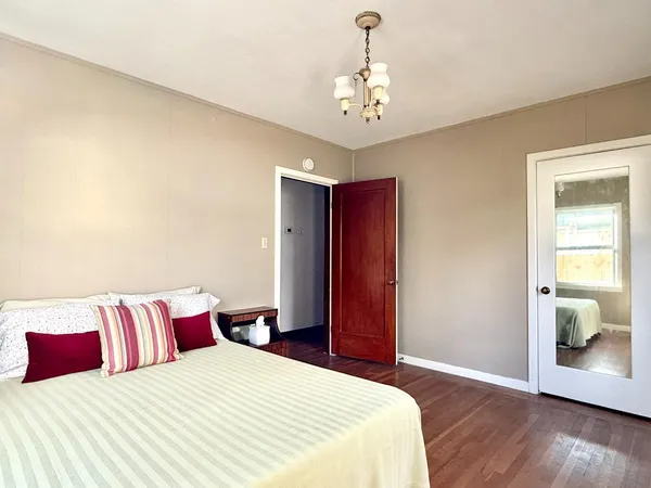 a bedroom with a large bed and a chandelier