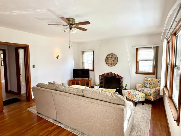 a living room with furniture a fireplace and a window