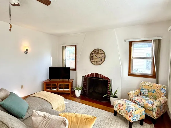 a living room with furniture a flat screen tv and a fireplace