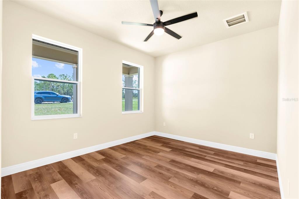 16143 Penn State Road Weeki Wachee, FL 34614 - Photo 20 of 45 a view of empty room with wooden floor and fan