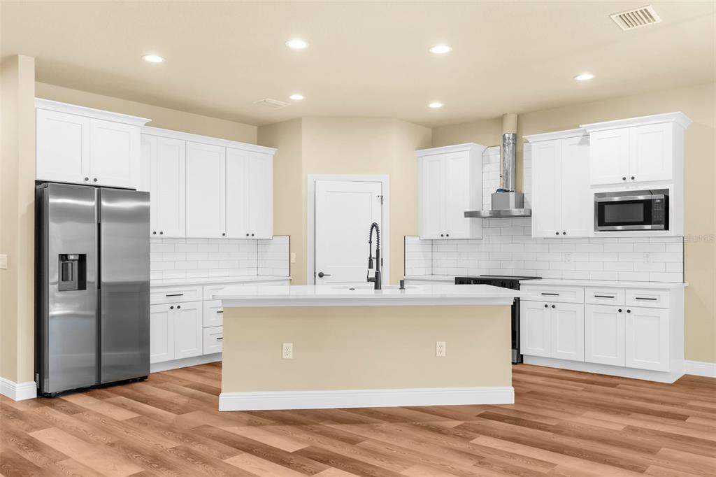 16143 Penn State Road Weeki Wachee, FL 34614 - Photo 2 of 45 a large kitchen with stainless steel appliances granite countertop a stove a sink and a refrigerator