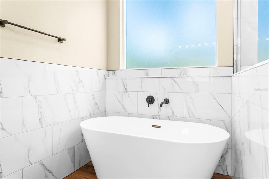 16143 Penn State Road Weeki Wachee, FL 34614 - Photo 24 of 45 a bathroom with a white bath tub and a shower