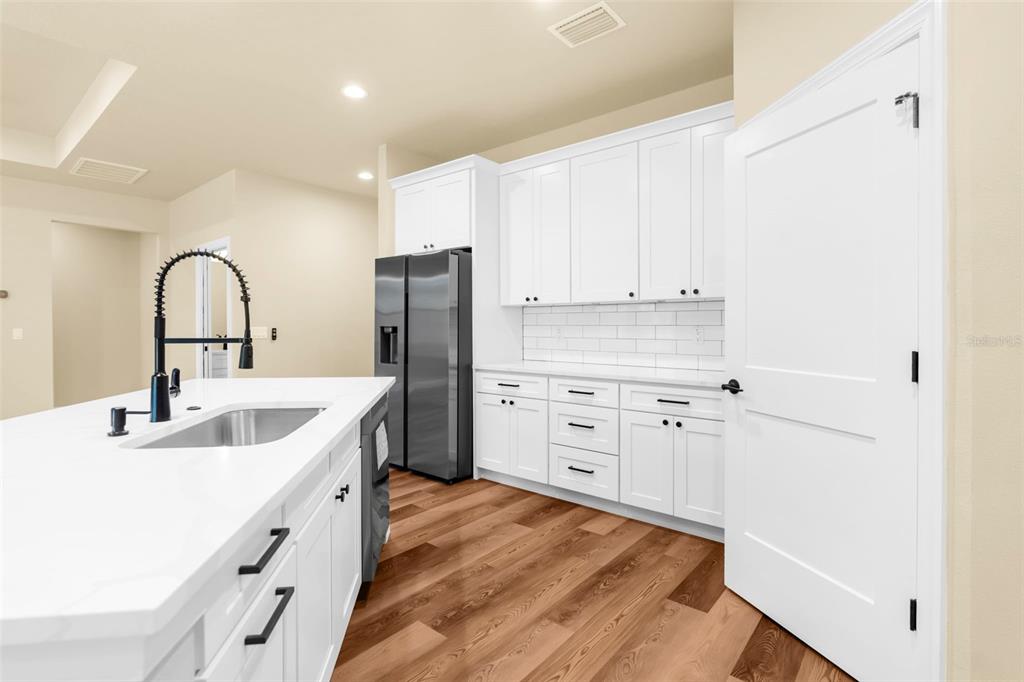 16143 Penn State Road Weeki Wachee, FL 34614 - Photo 30 of 45 a kitchen with stainless steel appliances a refrigerator sink and cabinets