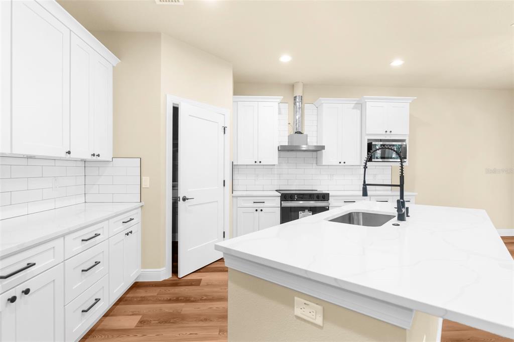 16143 Penn State Road Weeki Wachee, FL 34614 - Photo 3 of 45 a kitchen with granite countertop white cabinets and refrigerator