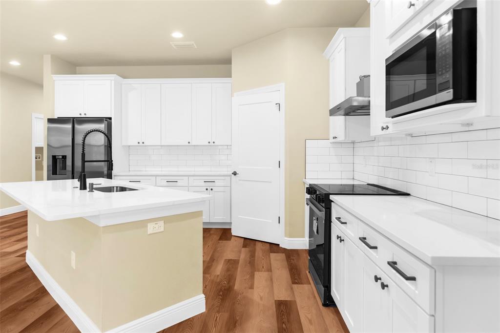 16143 Penn State Road Weeki Wachee, FL 34614 - Photo 31 of 45 a kitchen with appliances a sink and cabinets