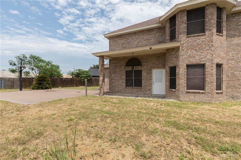 2001 Quail Lane Mission, TX 78572 - Photo 24 of 28 Brick exterior residence featuring a covered patio, arched window, and multiple window bays
