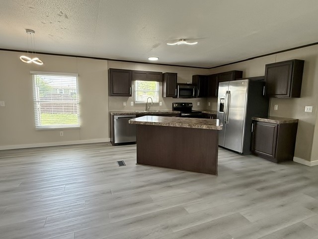 393 Duchess Pass Kyle, TX 78640 - Photo 4 of 14 An open-concept layout features a well-appointed kitchen and resilient vinyl plank flooring throughout.