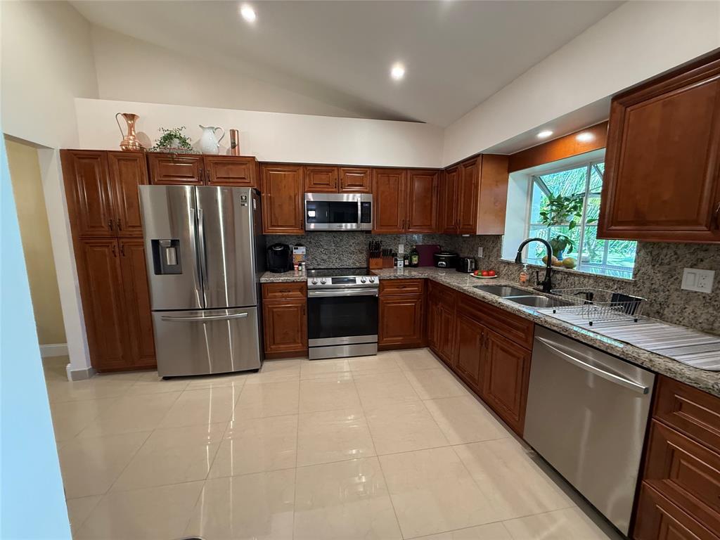 9237 Northwest 9th Place, Unit 9237 Plantation, FL 33324 - Photo 12 of 44 a kitchen with stainless steel appliances granite countertop a refrigerator a sink a stove a microwave a sink and a refrigerator