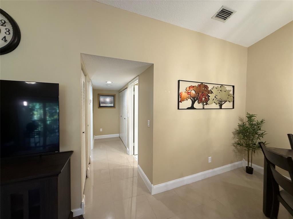 9237 Northwest 9th Place, Unit 9237 Plantation, FL 33324 - Photo 15 of 44 a view of a hallway with paintings on the wall