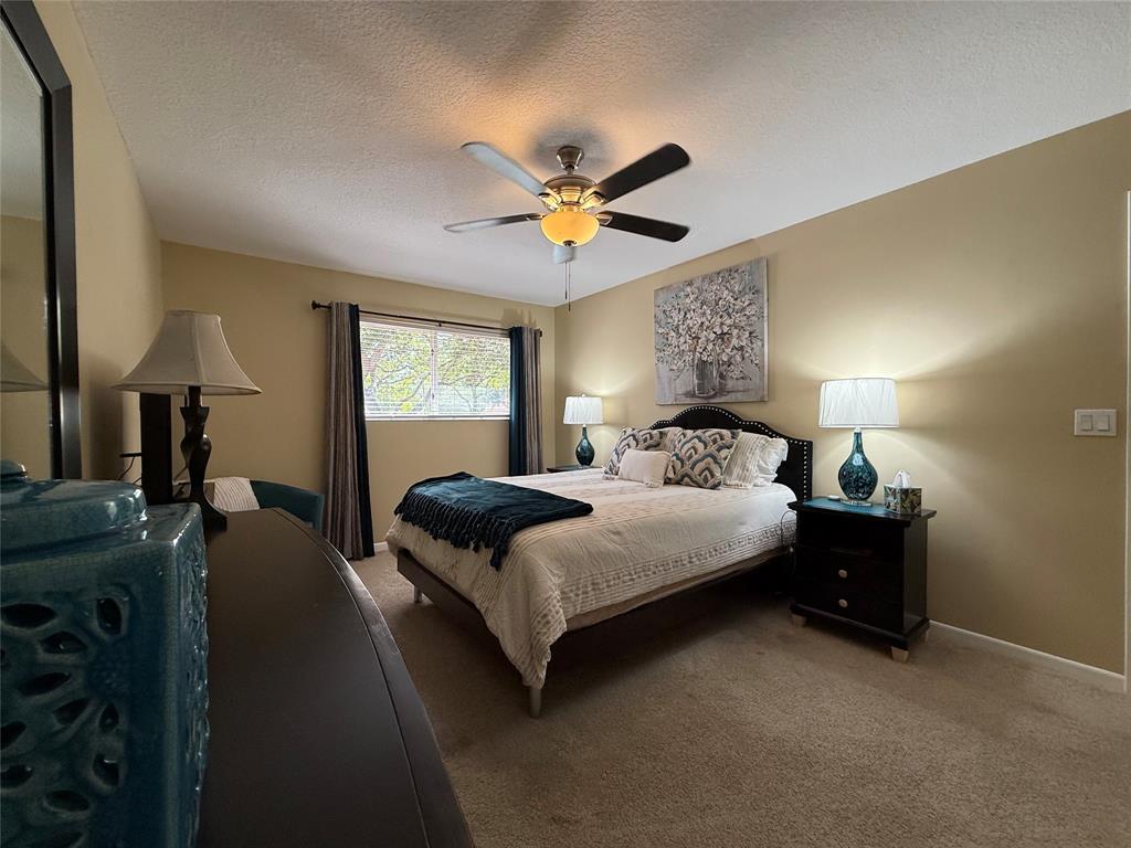 9237 Northwest 9th Place, Unit 9237 Plantation, FL 33324 - Photo 6 of 44 a bedroom with a bed and a chandelier fan