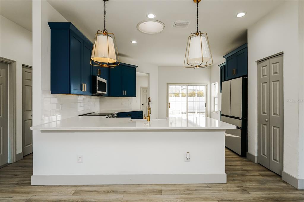 71 Westcedar Lane Palm Coast, FL 32164 - Photo 7 of 20 a kitchen with stainless steel appliances granite countertop a sink a microwave oven a refrigerator and white cabinets with wooden floor