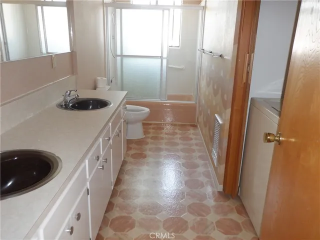 a bathroom with a tub shower sink and a mirror