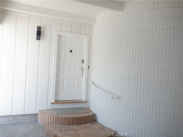 a bedroom with a large window and front door