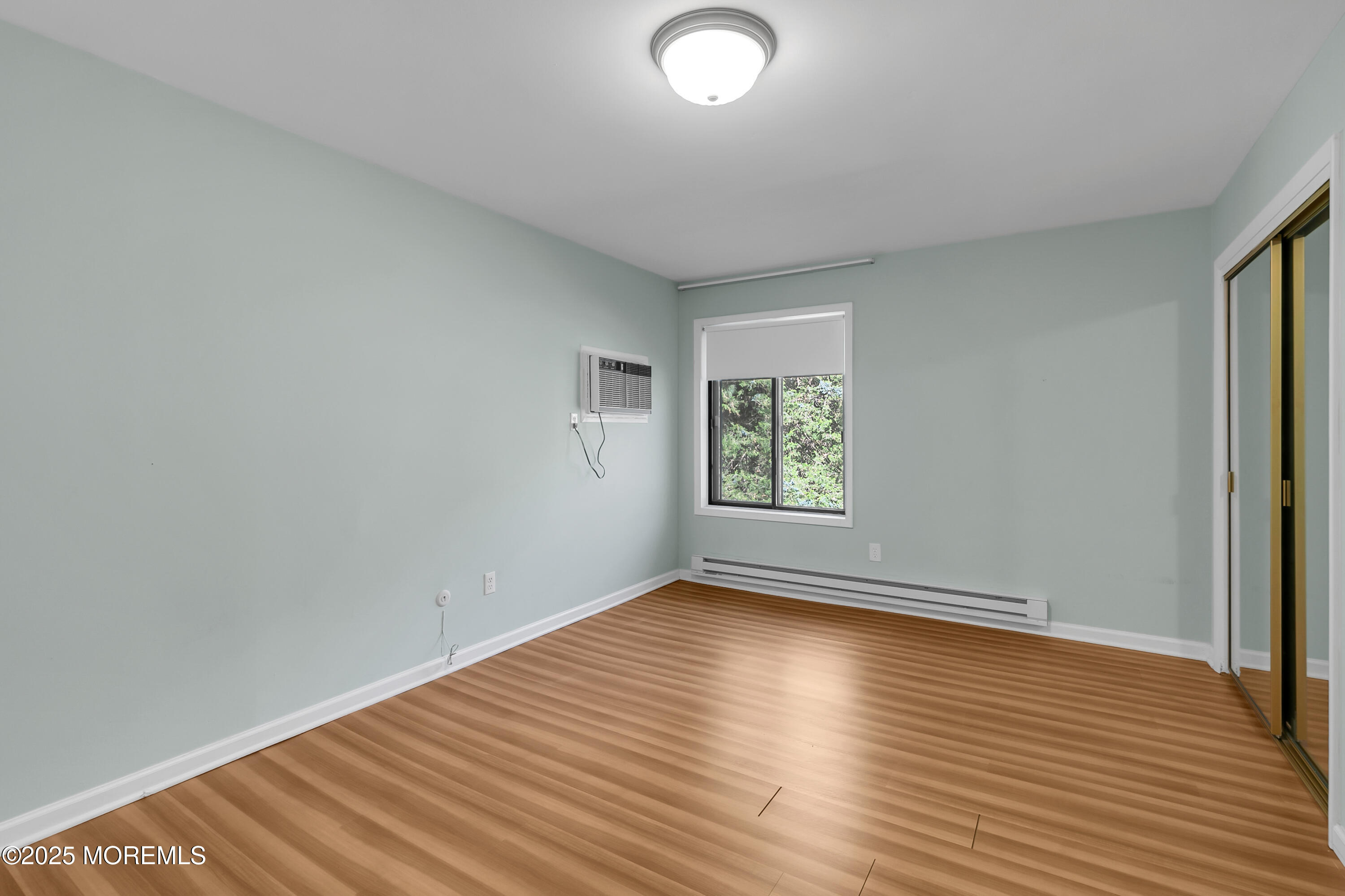 26 Meadow Green Circle, Unit K Manalapan, NJ 07726 - Photo 16 of 27 an empty room with wooden floor and windows