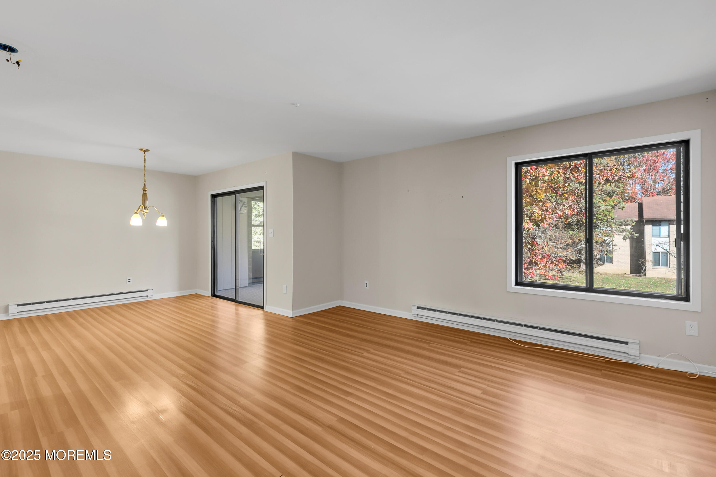 26 Meadow Green Circle, Unit K Manalapan, NJ 07726 - Photo 8 of 27 an empty room with wooden floor and windows