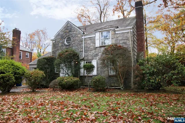 a view of a brick house with a yard and plants