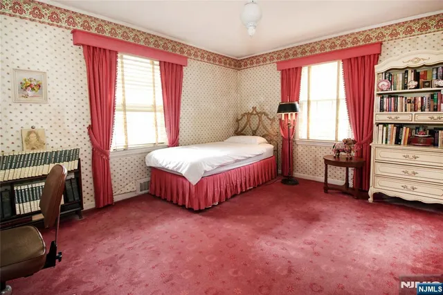 a spacious bedroom with a bed and a book shelf