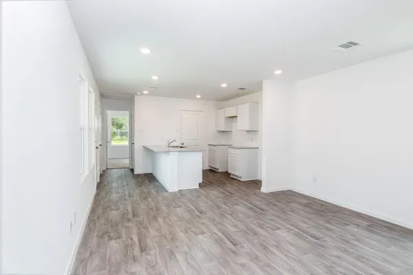 a view of a kitchen with wooden floor and a sink