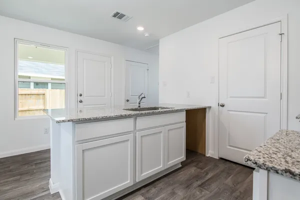a kitchen with granite countertop white cabinets and white appliances