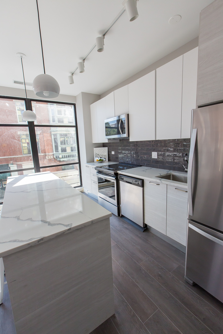Undisclosed Address Chicago, IL 60610 - Photo 5 of 14 a kitchen with stainless steel appliances granite countertop a refrigerator a stove and a sink with wooden floors
