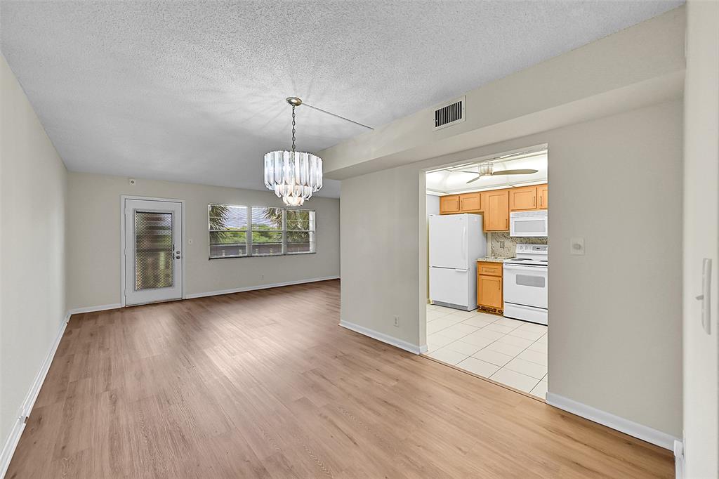 1902 Bermuda Circle, Unit H3 Coconut Creek, FL 33066 - Photo 12 of 25 a view of a room with wooden floor kitchen chandelier and windows