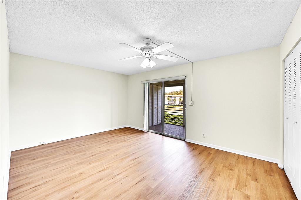 1902 Bermuda Circle, Unit H3 Coconut Creek, FL 33066 - Photo 16 of 25 a view of an empty room with window and wooden floor