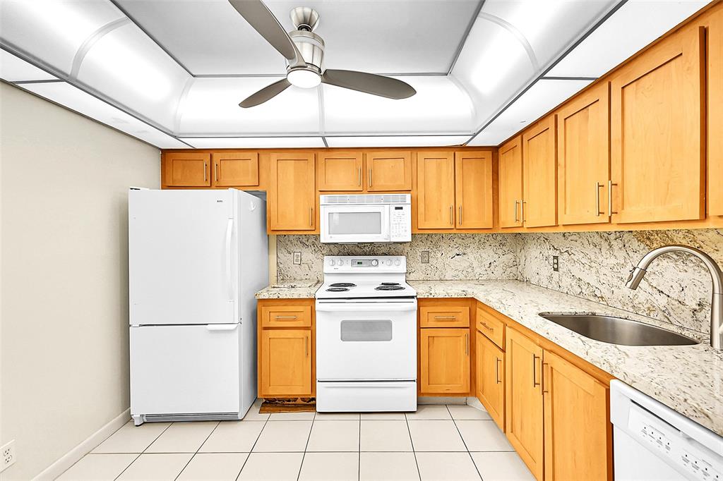1902 Bermuda Circle, Unit H3 Coconut Creek, FL 33066 - Photo 2 of 25 a kitchen with a sink a refrigerator and cabinets