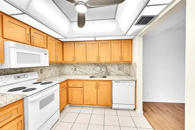 a kitchen with a stove sink and cabinets