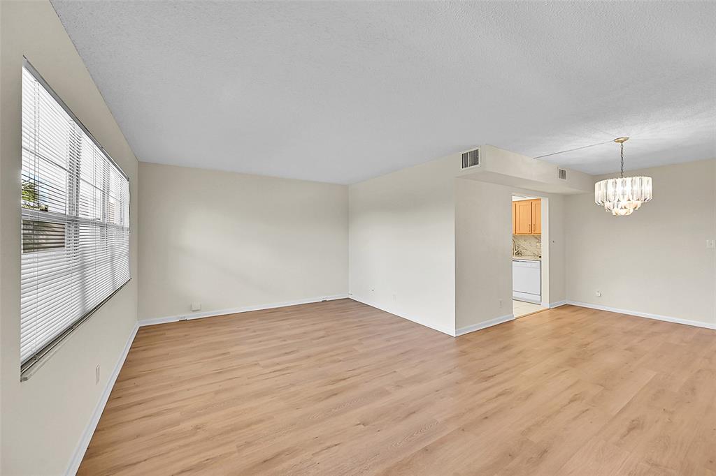 1902 Bermuda Circle, Unit H3 Coconut Creek, FL 33066 - Photo 10 of 25 a view of an empty room with wooden floor and a window