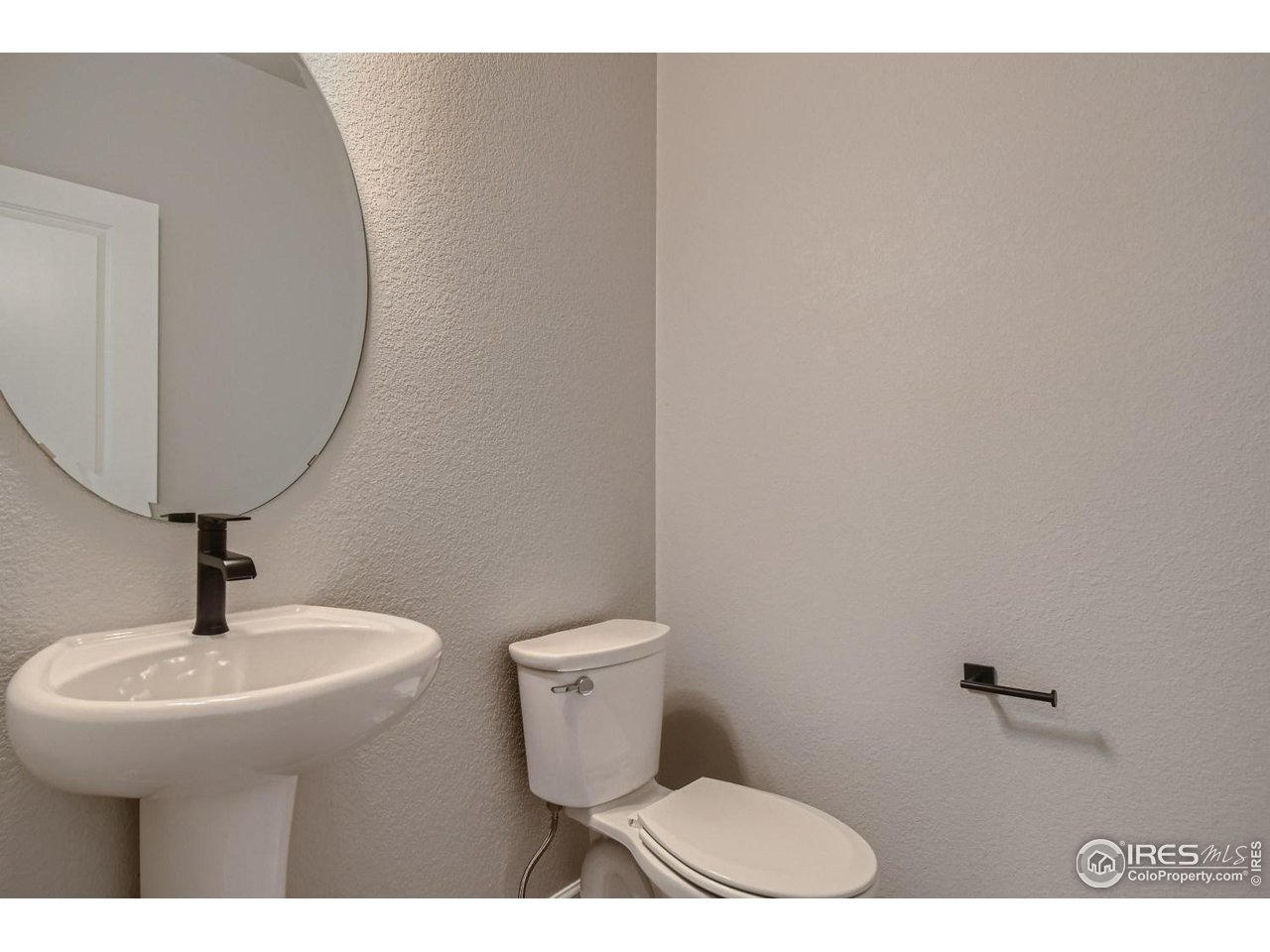 2540 Brookstone Drive, Unit B Milliken, CO 80543 - Photo 11 of 25 a bathroom with a toilet a sink and mirror
