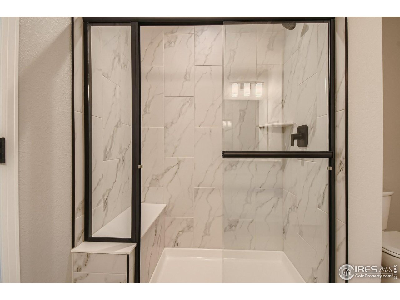 2540 Brookstone Drive, Unit B Milliken, CO 80543 - Photo 18 of 25 a bathroom with a glass shower door