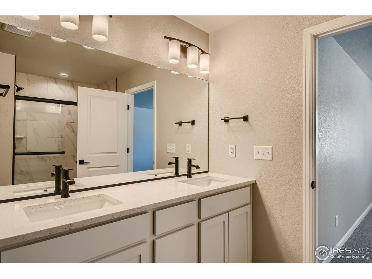2540 Brookstone Drive, Unit B Milliken, CO 80543 - Photo 19 of 25 a bathroom with a double vanity sink a mirror and a shower