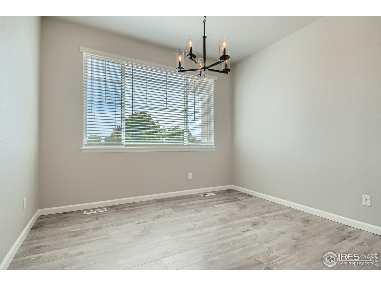 2540 Brookstone Drive, Unit B Milliken, CO 80543 - Photo 4 of 25 an empty room with wooden floor and windows