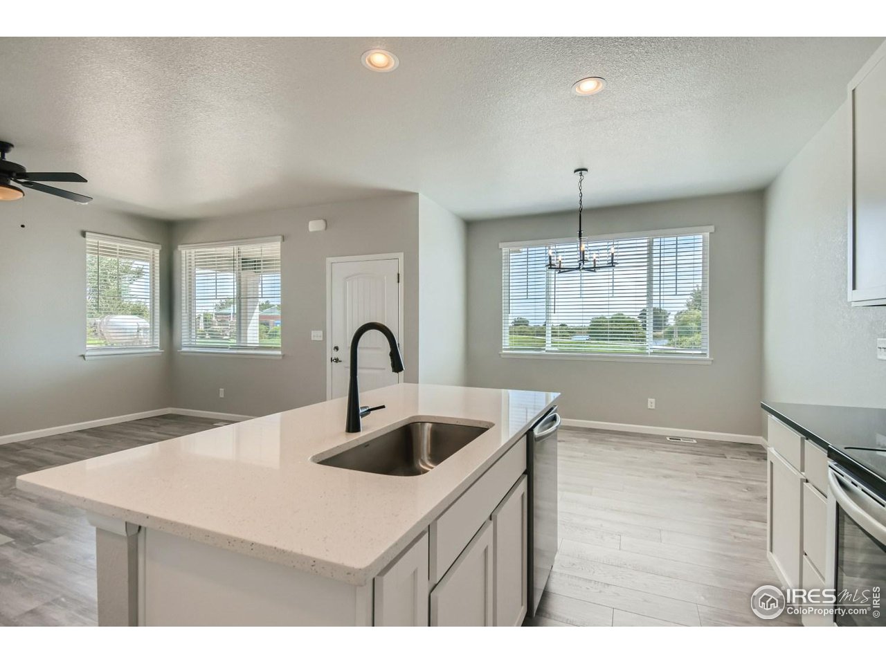 2540 Brookstone Drive, Unit B Milliken, CO 80543 - Photo 8 of 25 a kitchen with a sink a counter space and chandelier