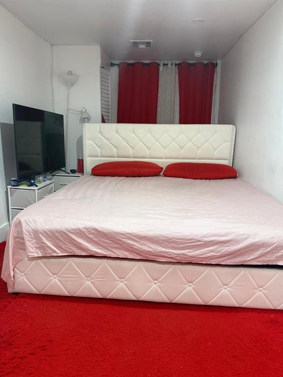 1116 West 32nd Street Riviera Beach, FL 33404 - Photo 5 of 12 a bedroom with a bed and a flat screen tv