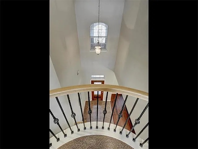 1832 Nelson Ranch Loop Cedar Park, TX 78613 - Photo 7 of 15 A graceful curved staircase with ornate iron balusters and wood railing leads to an illuminated foyer.