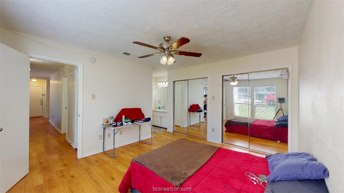 1005 Spring Loop, Unit D College Station, TX 77840 - Photo 15 of 25 a bedroom with a bed and a chandelier