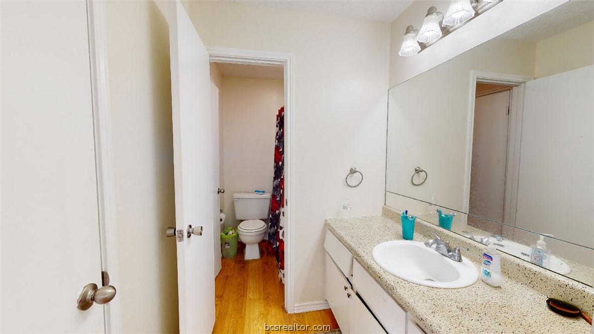 1005 Spring Loop, Unit D College Station, TX 77840 - Photo 21 of 25 a bathroom with a granite countertop sink and a mirror