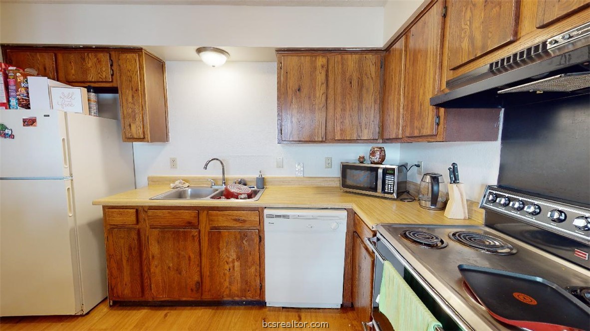 1005 Spring Loop, Unit D College Station, TX 77840 - Photo 8 of 25 a kitchen with a stove and a refrigerator